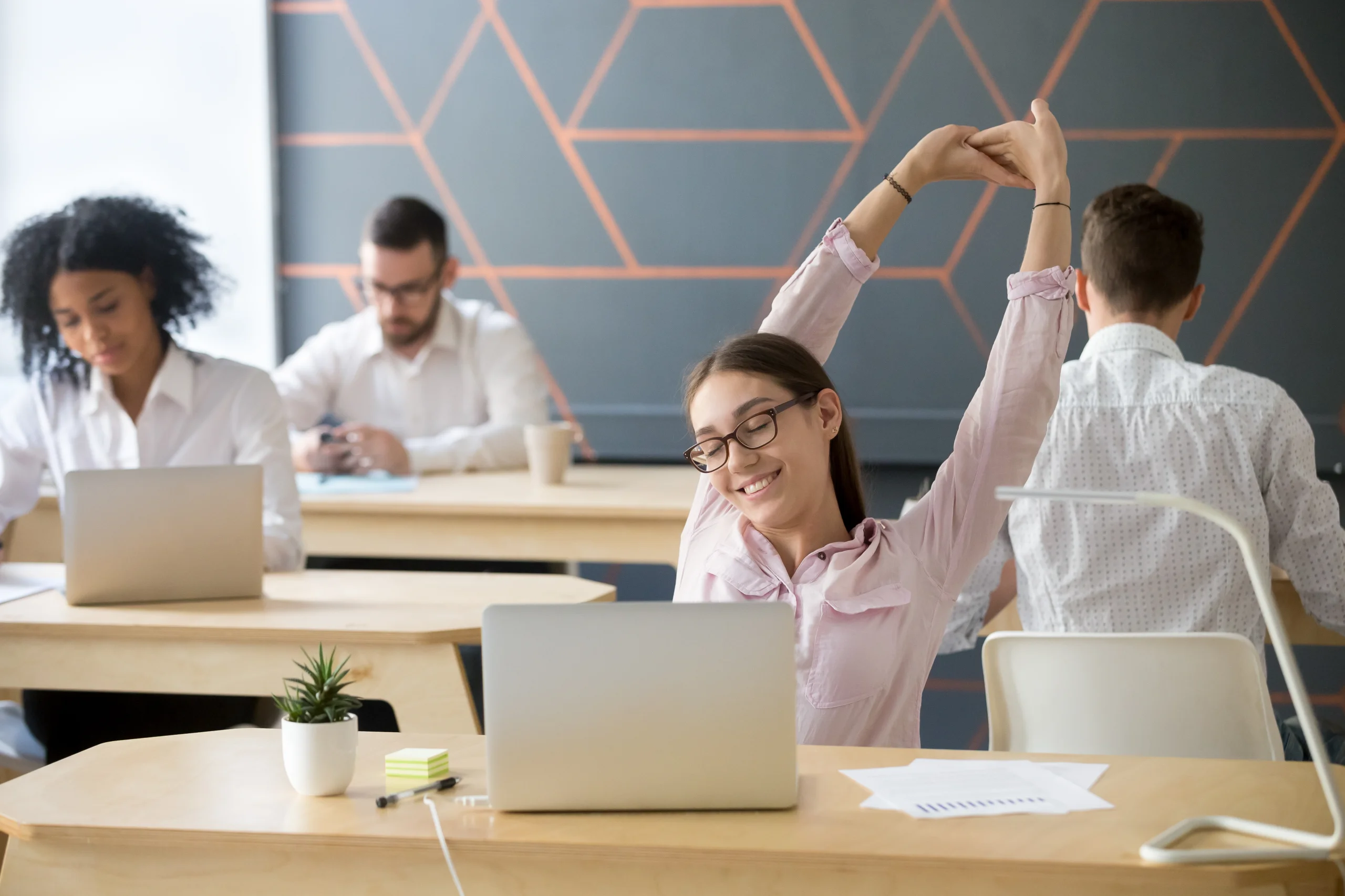 millennial employee stretching taking break from computer work f