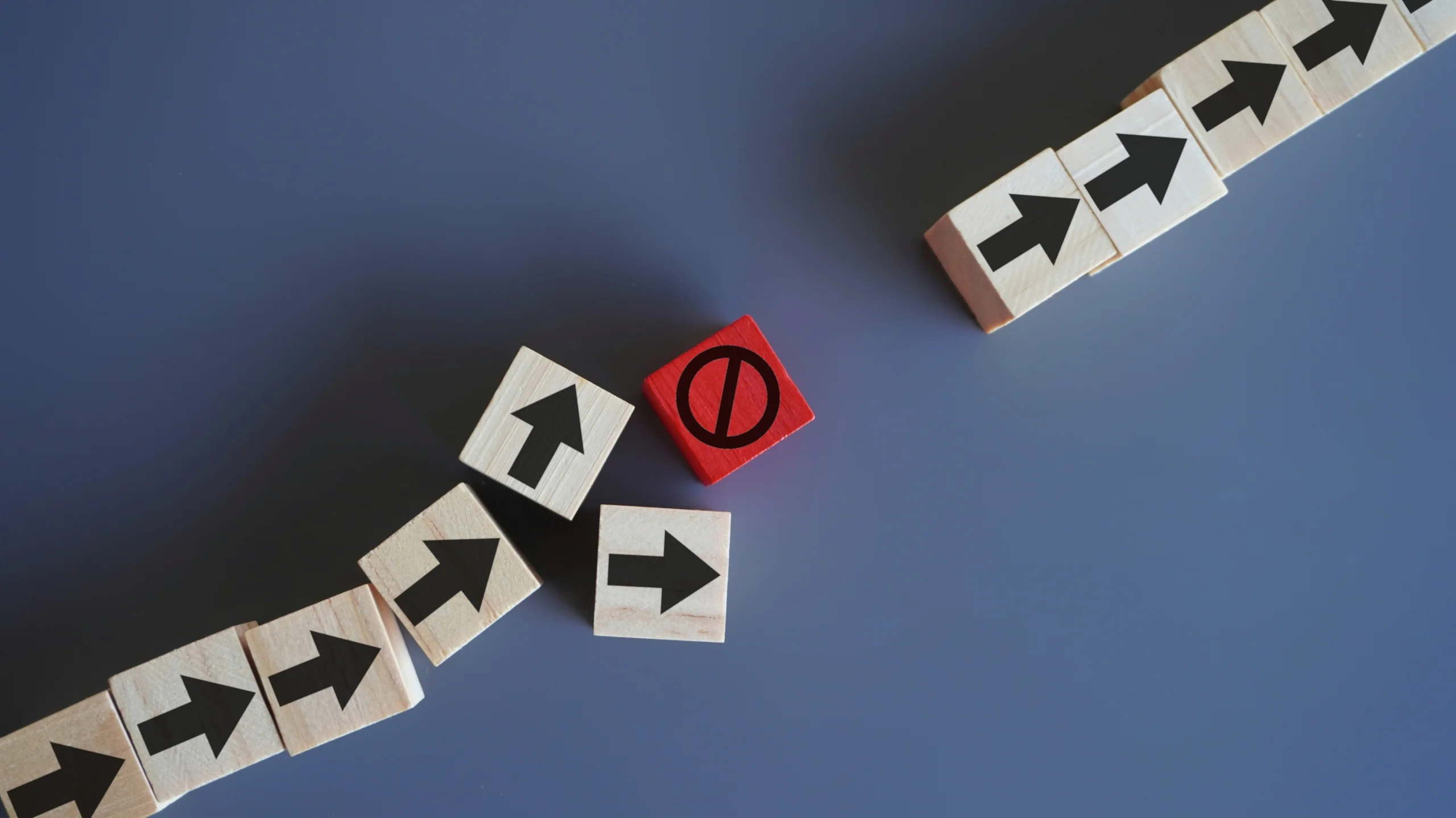 wooden blocks with arrow stop icon delays disruptions stop process critical error